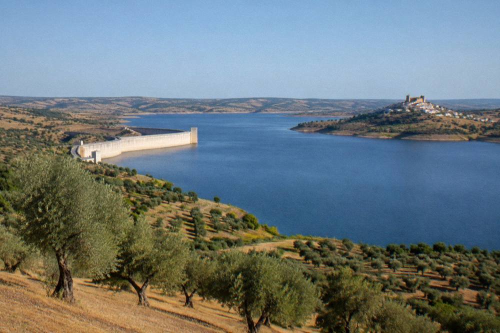 Walled hilltop village of Monsaraz above the Alqueva lake at golden hour