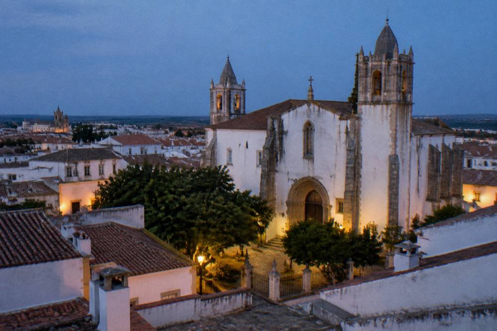 Evening view of Évora's rooftops and church towers seen from a terrace above the old town