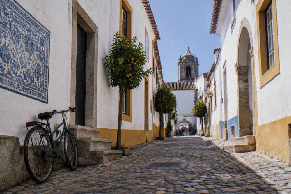 Whitewashed lane with azulejo tiles and a bicycle leaning against a wall in old Évora
