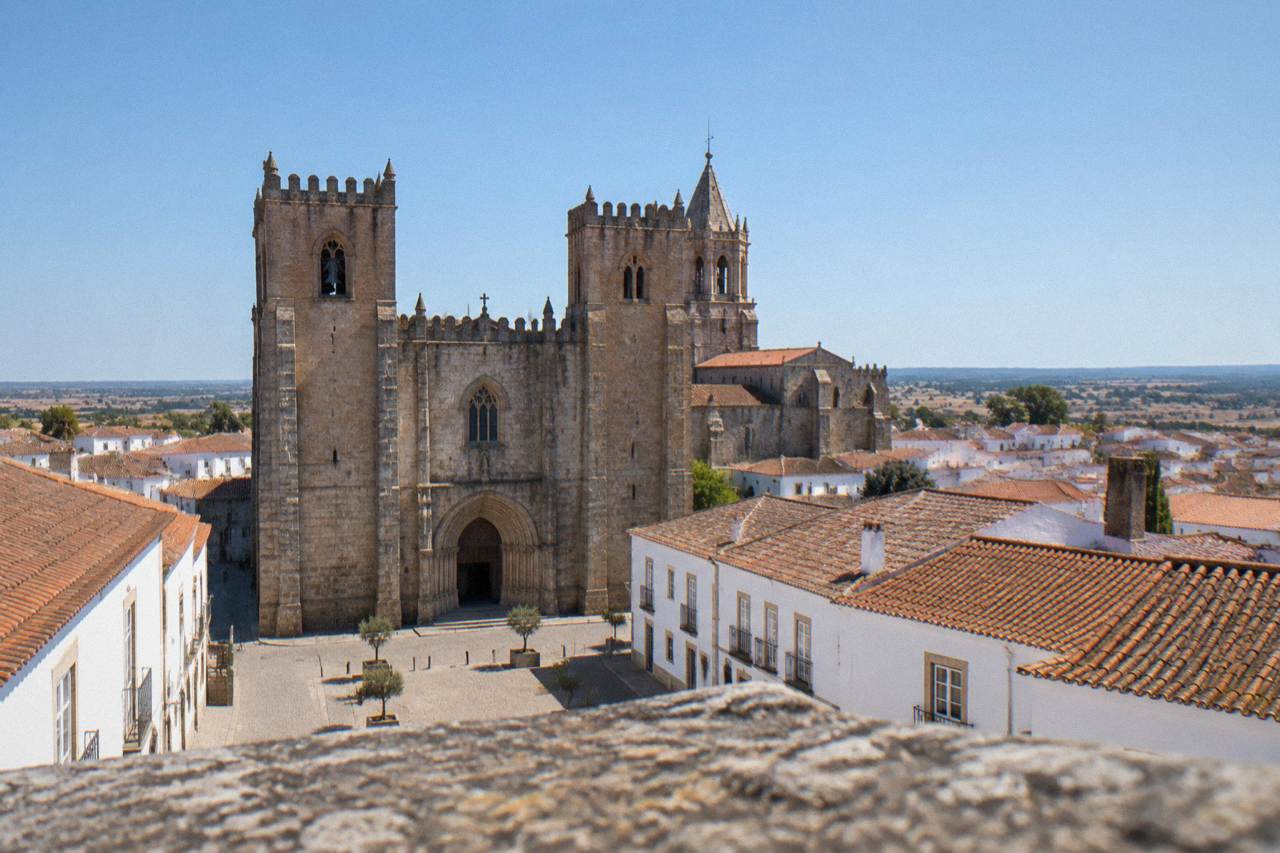 Wide view of Évora's historic centre rooftops and the Sé cathedral tower under a clear Alentejo sky
