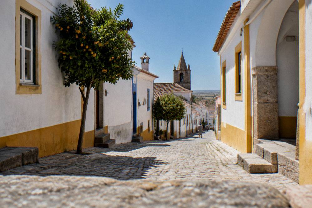 Hilltop village above the Alentejo plain seen from a quiet country road