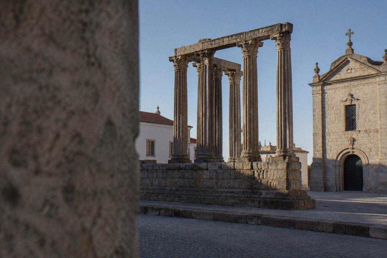 The columns of the Roman temple in Évora rising above a quiet square at golden hour