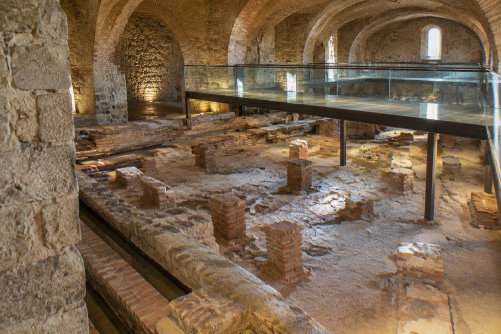 Brick vaults and stone channels of the Roman baths preserved beneath a building in Évora