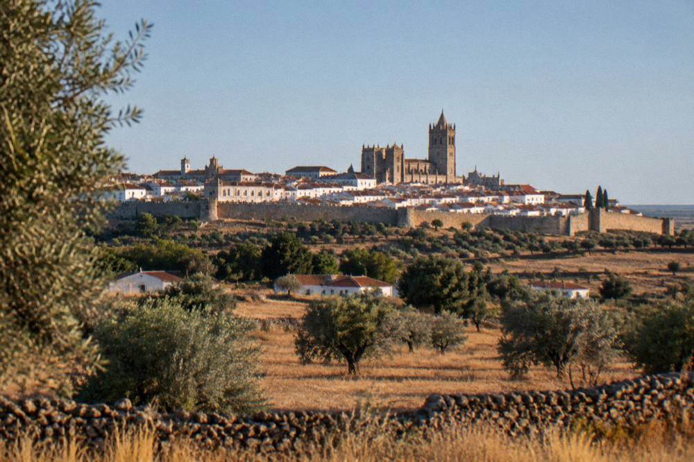 The walled historic centre of Évora seen from a distance across the Alentejo plain