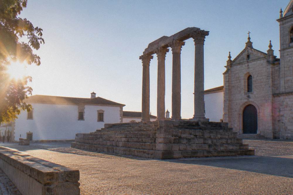 Roman temple with stone columns standing in a square in Évora at golden hour