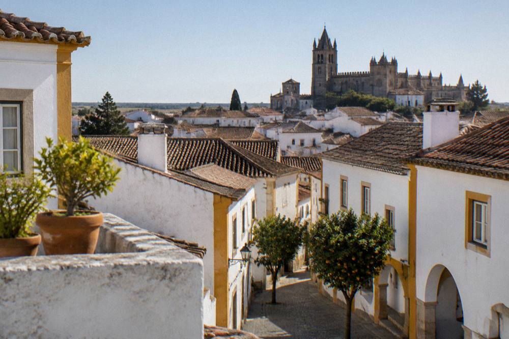 Rooftops of Évora seen from a high terrace with the cathedral silhouette beyond