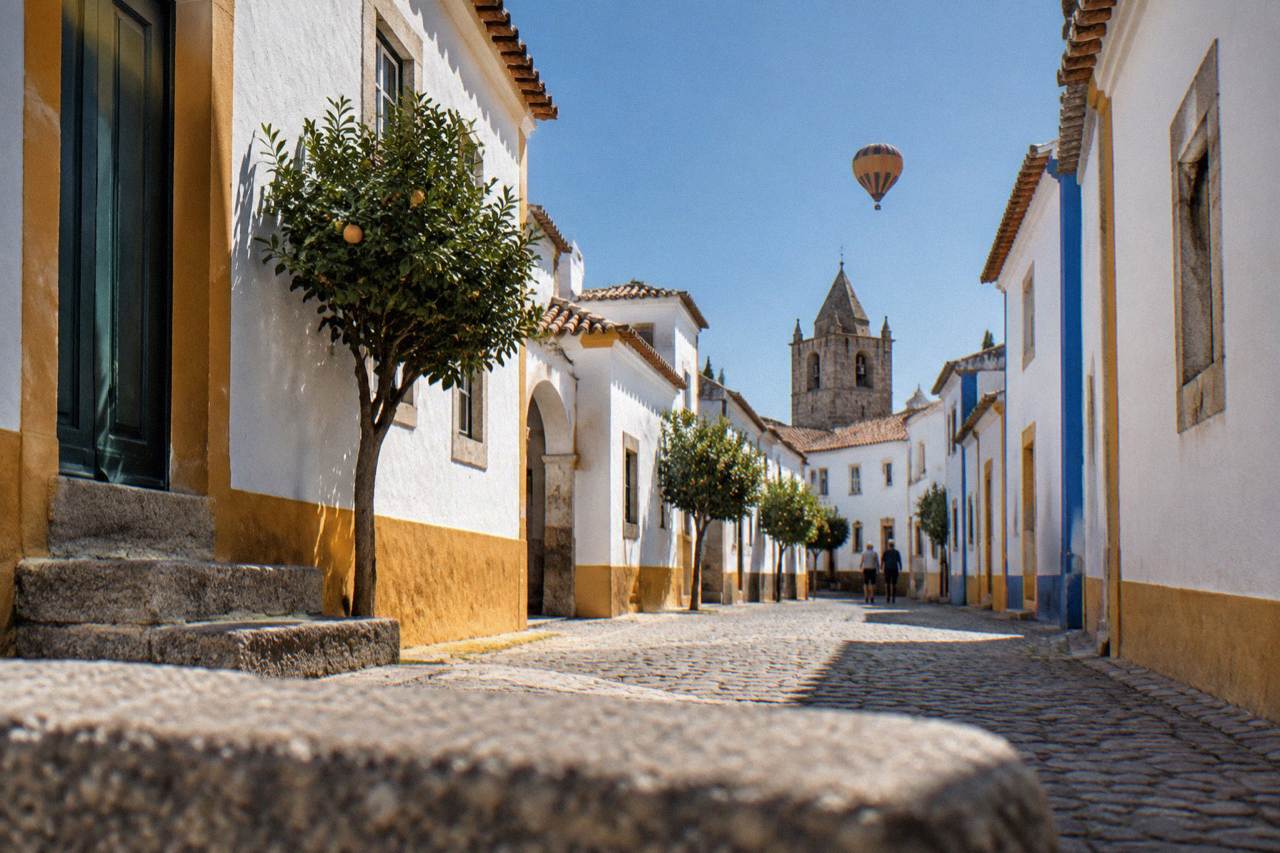 A hot air balloon drifting above the walled historic centre of Évora at sunrise