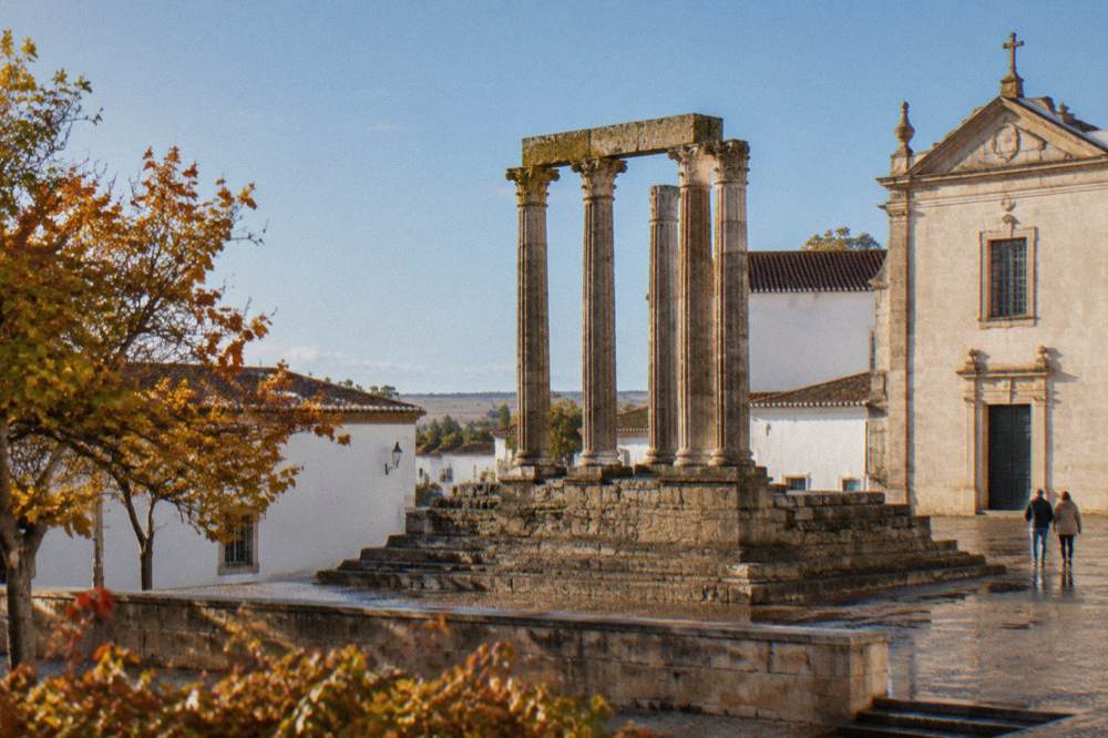The Roman temple columns of Évora standing against a clear blue autumn sky