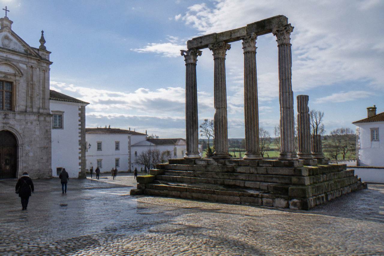 Évora's whitewashed old town under a soft winter sky, with the Roman temple columns standing on a quiet square