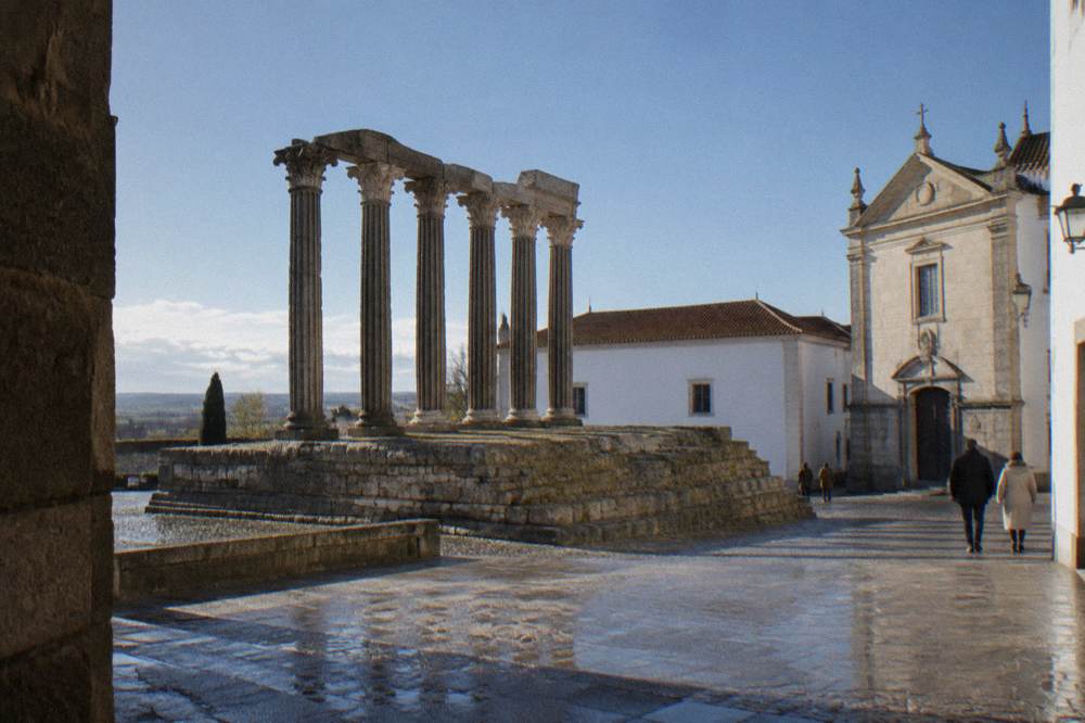 The Roman temple of Évora with its granite columns in low angled winter sunlight against a pale sky