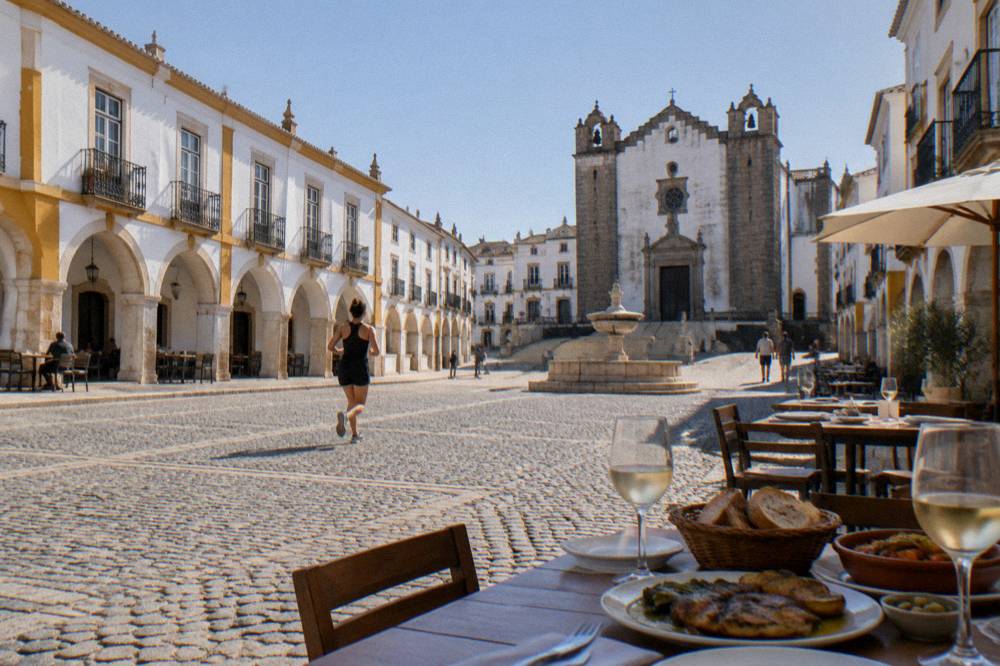 A dinner table with wine glasses, bread and grilled dishes on an evening terrace in the Alentejo
