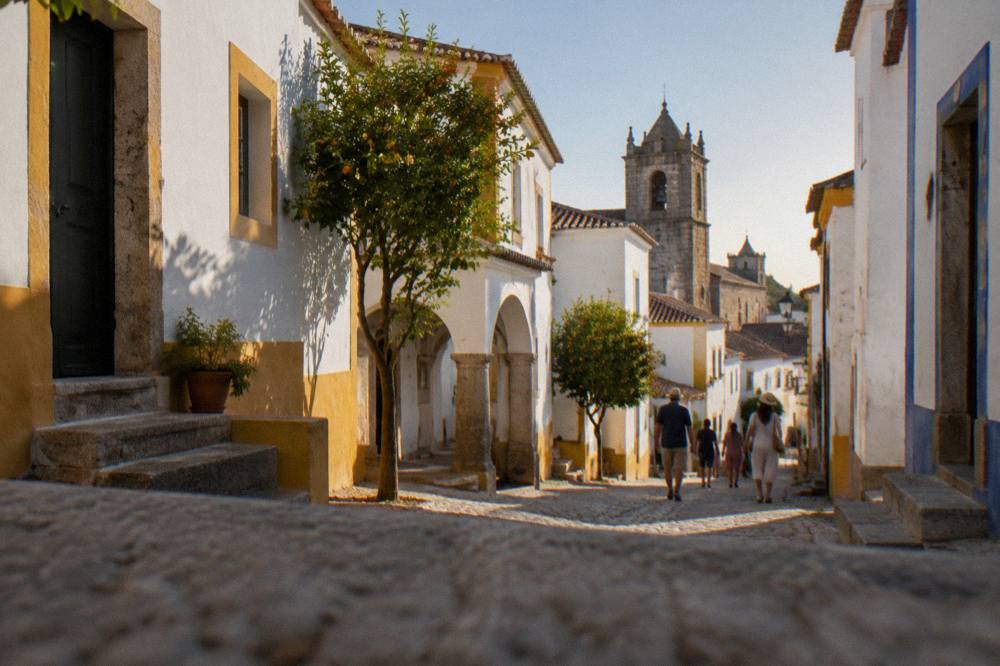 A warm summer evening sky above the rooftops and church towers of Évora