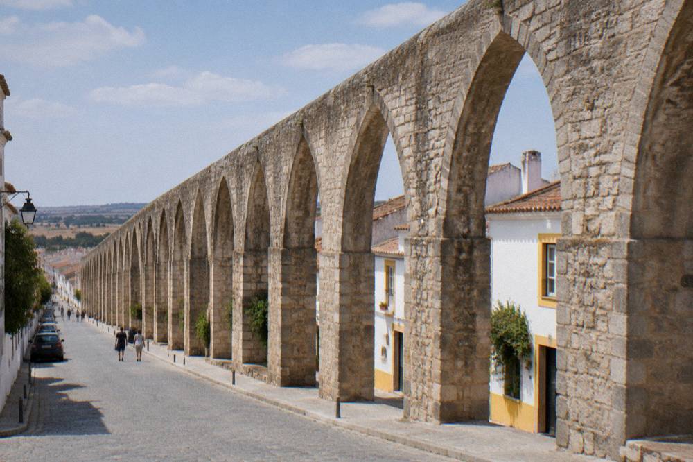 Arches of the Água de Prata aqueduct entering Évora with houses built between the piers