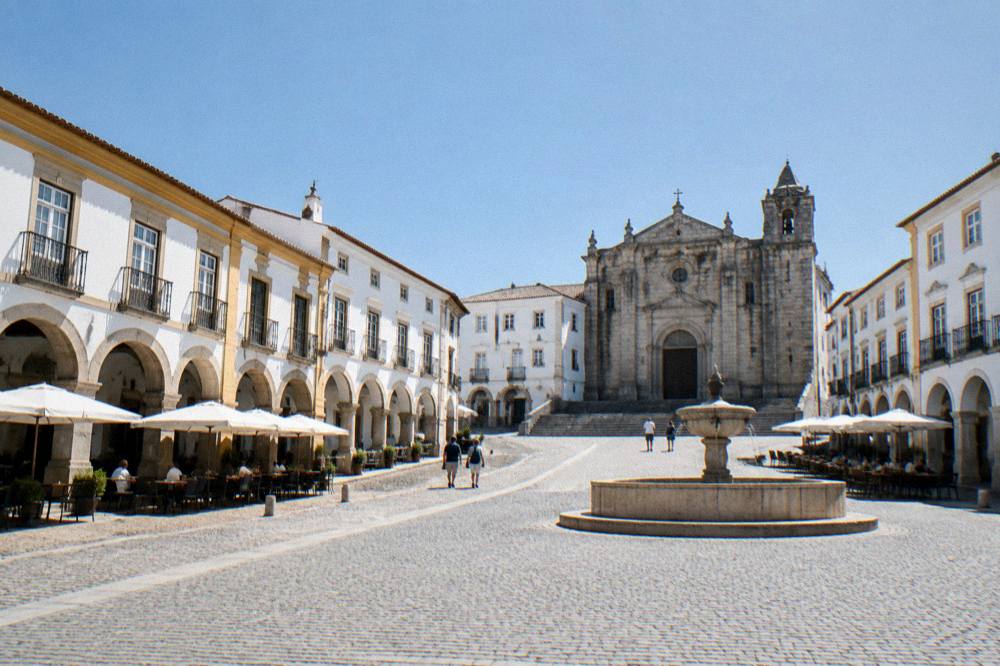Arcaded square of Praça do Giraldo with café tables under the arches