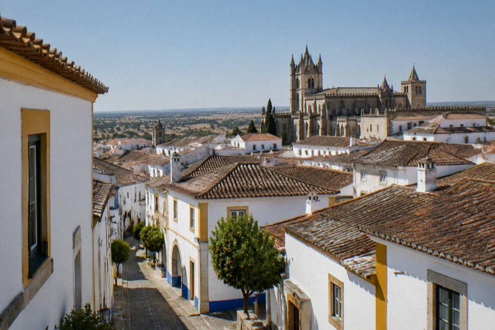 Rooftops of Évora seen from a high terrace with the cathedral silhouette in the evening light