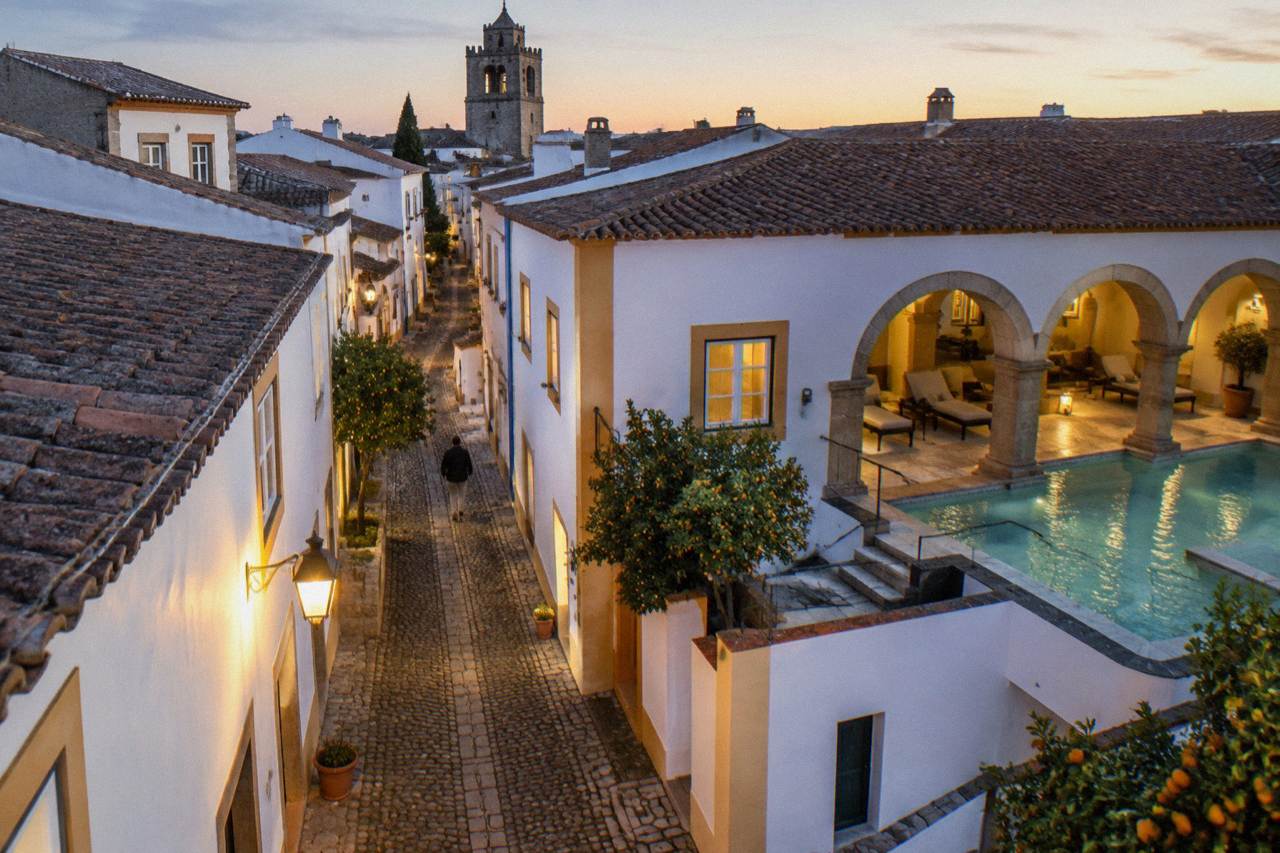 A calm hotel spa pool in Évora with stone arches and warm evening light