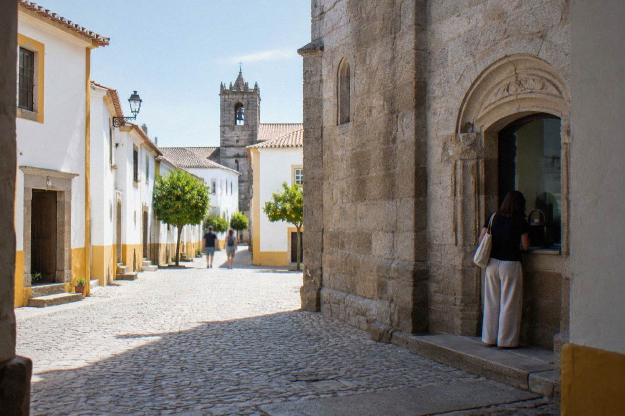 Ticket window of a stone church in the historic centre of Évora with a visitor buying entry