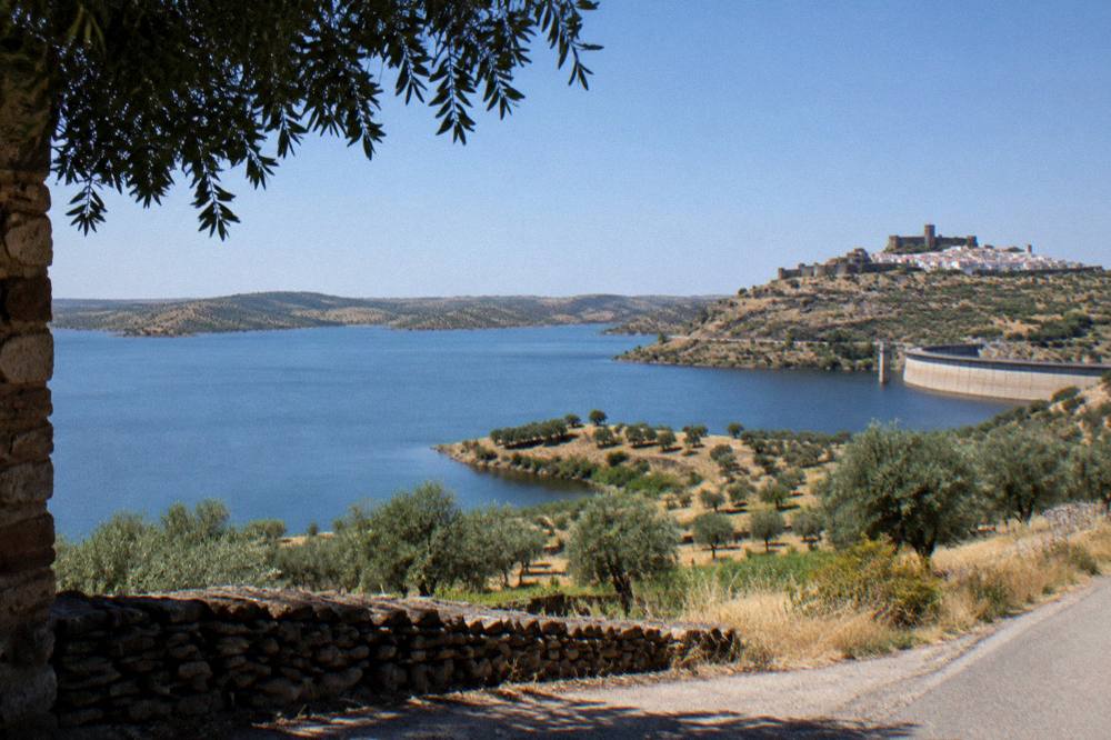 Walled hilltop village of Monsaraz above the Alqueva lake seen from a country road