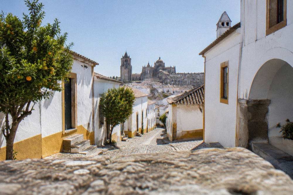 The roof terrace view over Évora's cathedral, domes and low white rooftops at golden hour