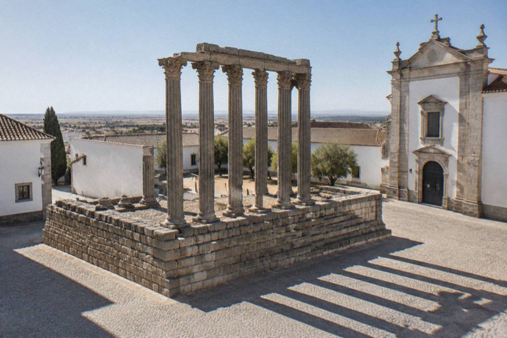 Roman temple columns in Évora against a clear sky
