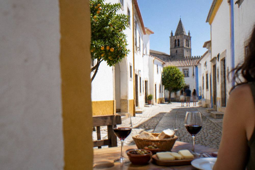 A table with red wine glasses, bread, cheese and olives in an Alentejo restaurant
