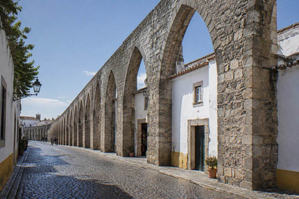 The arches of the Água de Prata aqueduct passing between houses in Évora