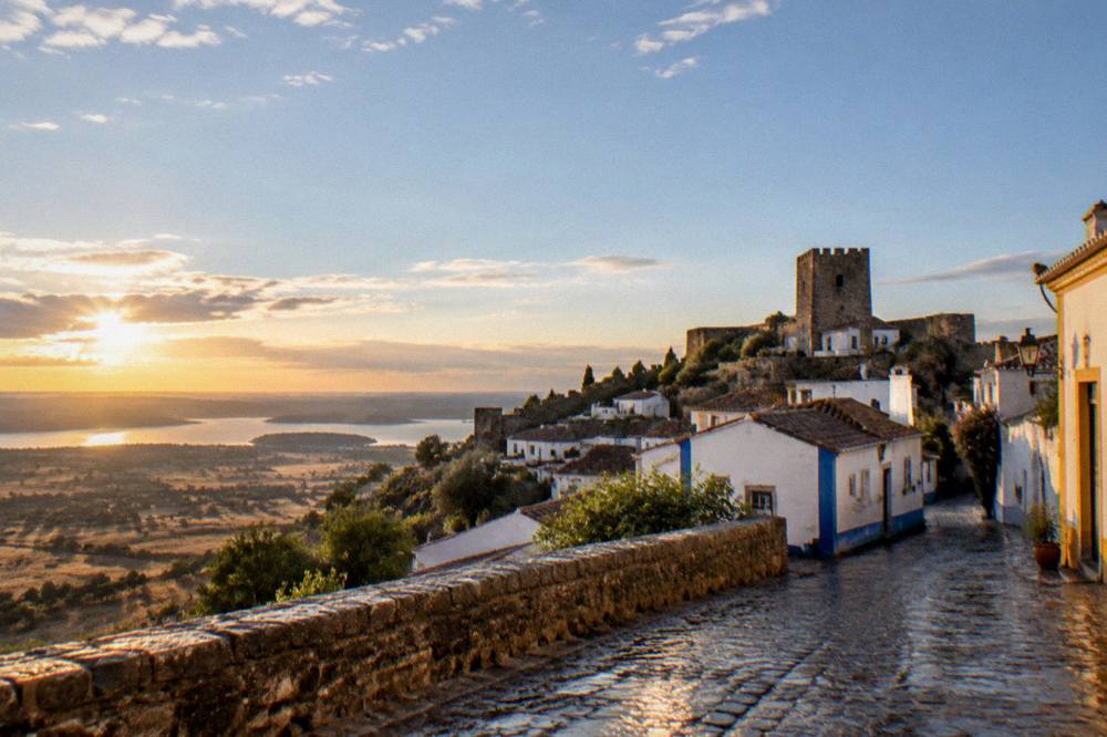 The hilltop village of Monsaraz above the Alentejo plain and lake at golden hour