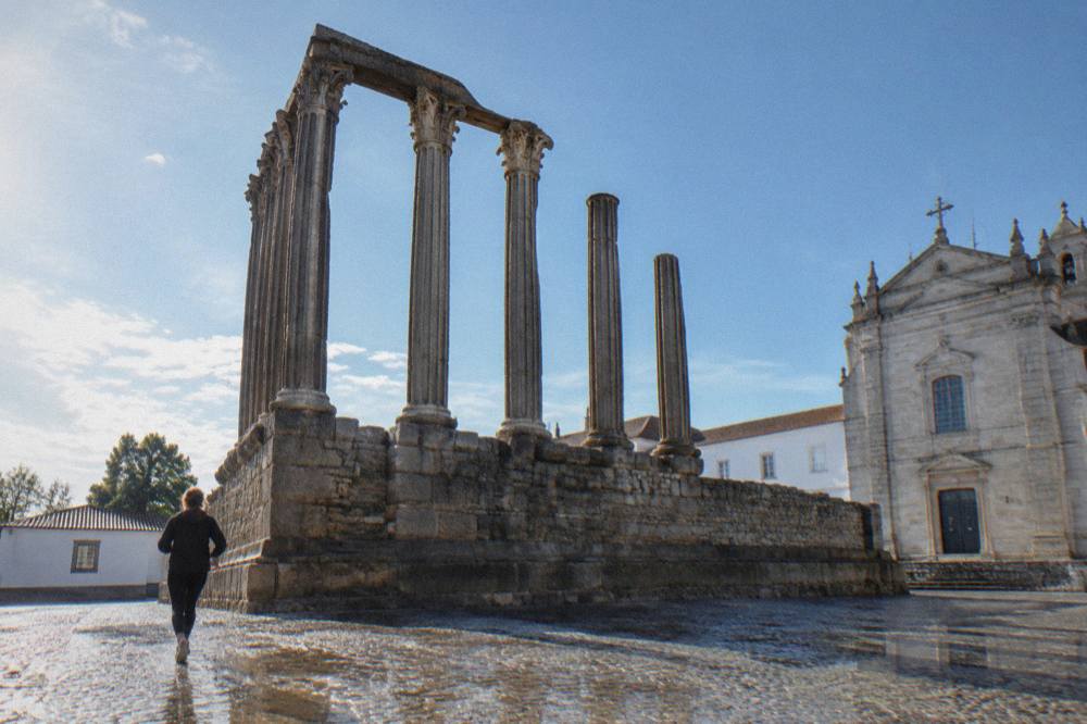 The granite columns of the Roman temple in Évora seen from below with the blue sky behind them