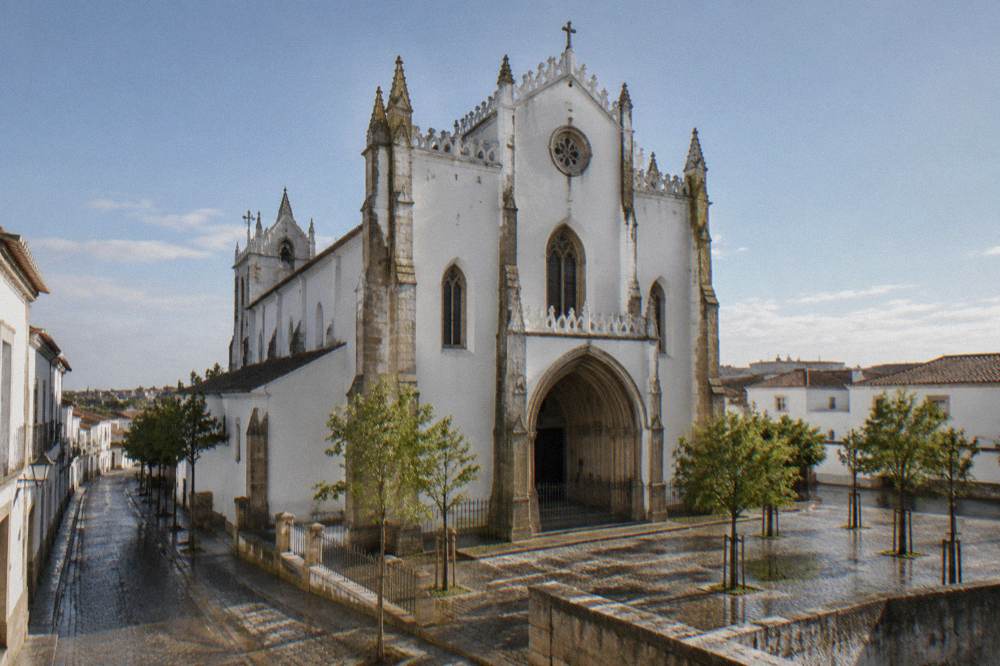 The Gothic facade of the Church of São Francisco in Évora seen from the street in late afternoon light