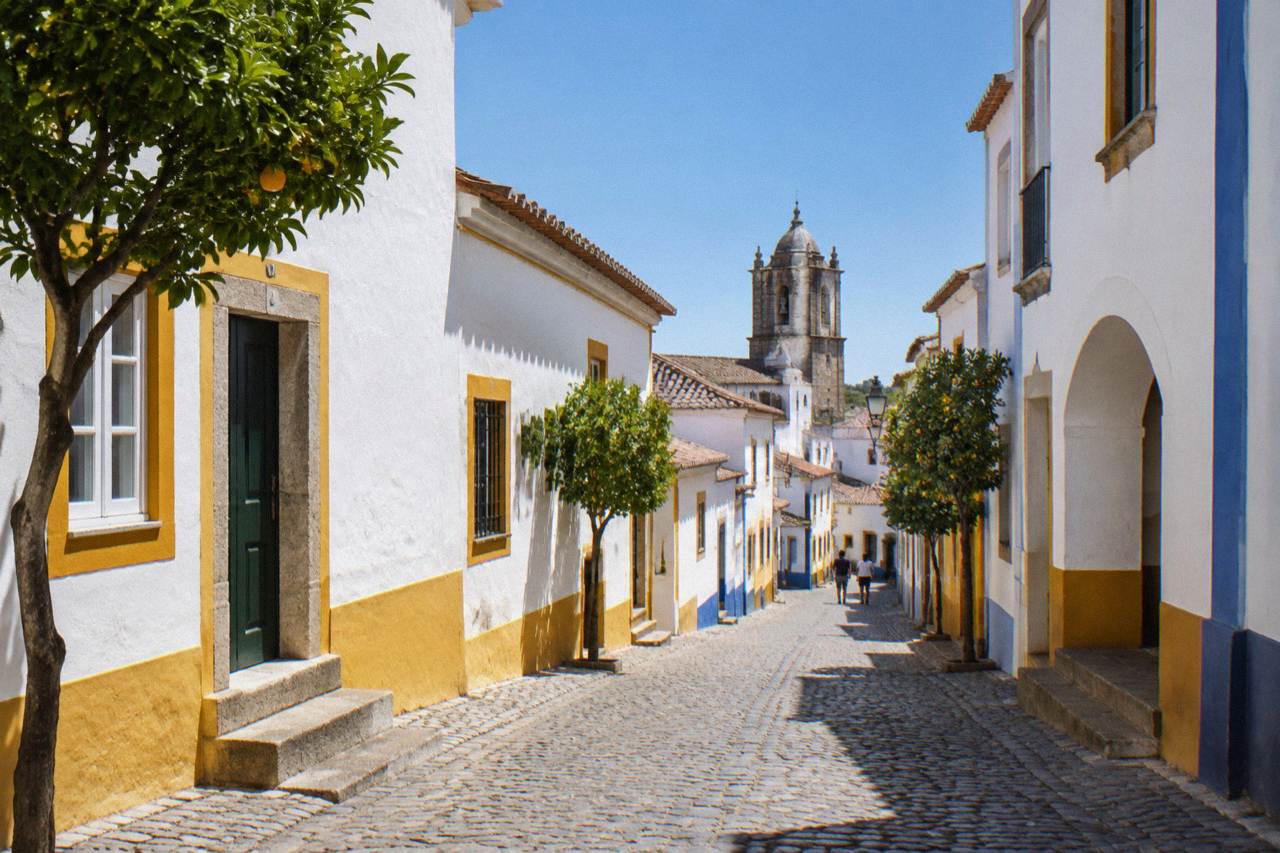 Narrow cobbled street inside the walled historic centre of Évora with whitewashed houses