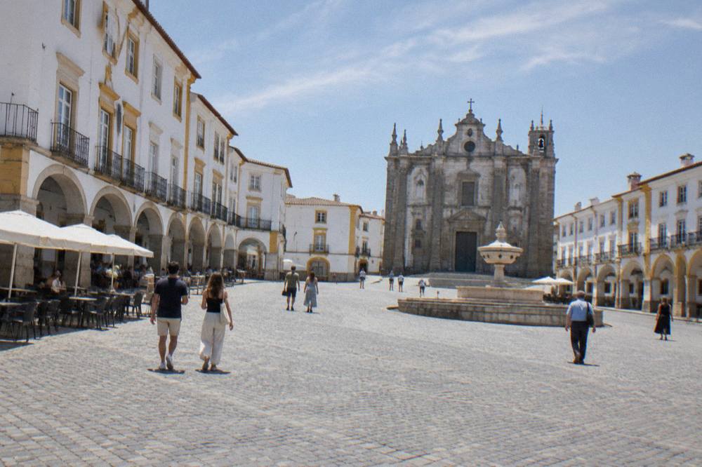 Pedestrians crossing the Praça do Giraldo in front of the arcade buildings