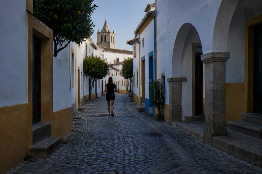 Shaded narrow street in Évora with whitewashed walls offering relief from the sun