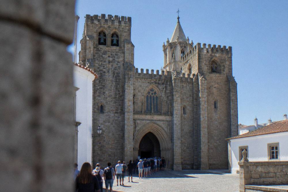 Visitors queuing at an entrance of the Évora cathedral on a bright morning