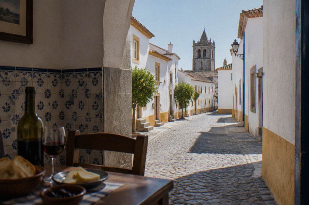 A table set with Alentejo wine, bread and cheese in a tiled tavern room
