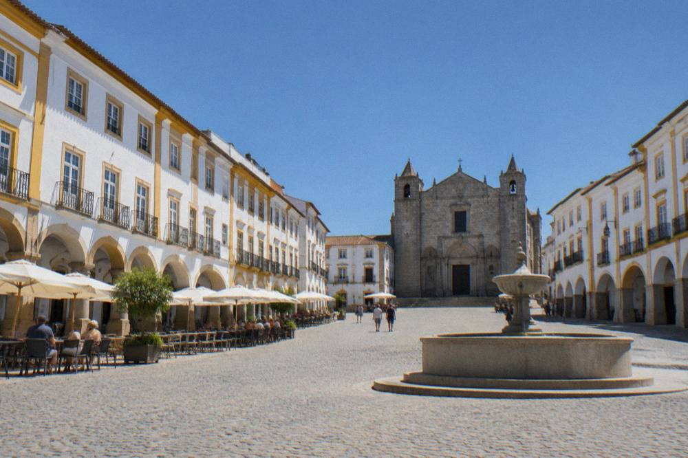 Praça do Giraldo in Évora with its arched arcades and café tables along one side