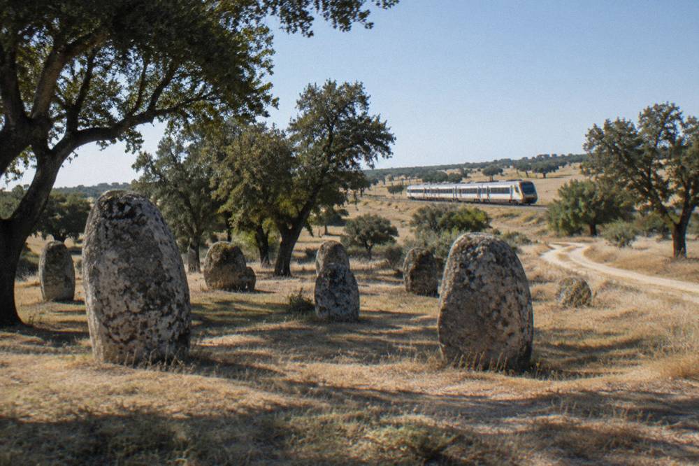 A train travelling through open Alentejo countryside toward Évora on a bright morning