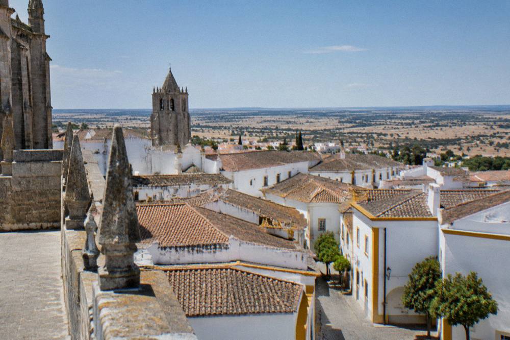 The roofline of Évora seen from the cathedral roof terrace with the Alentejo plain beyond