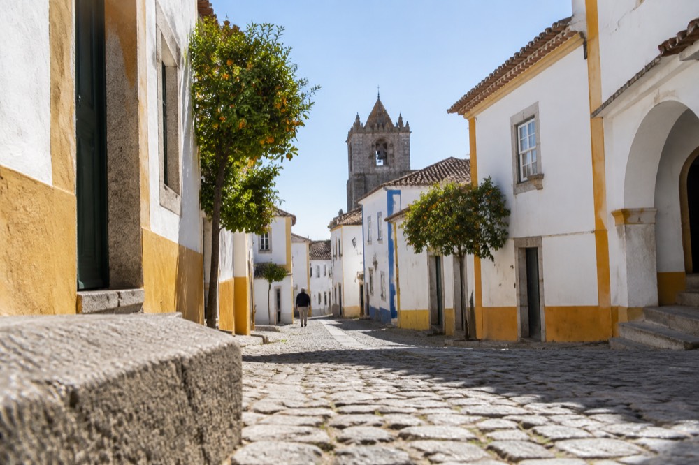 Regional train standing at a small Alentejo station platform in the morning