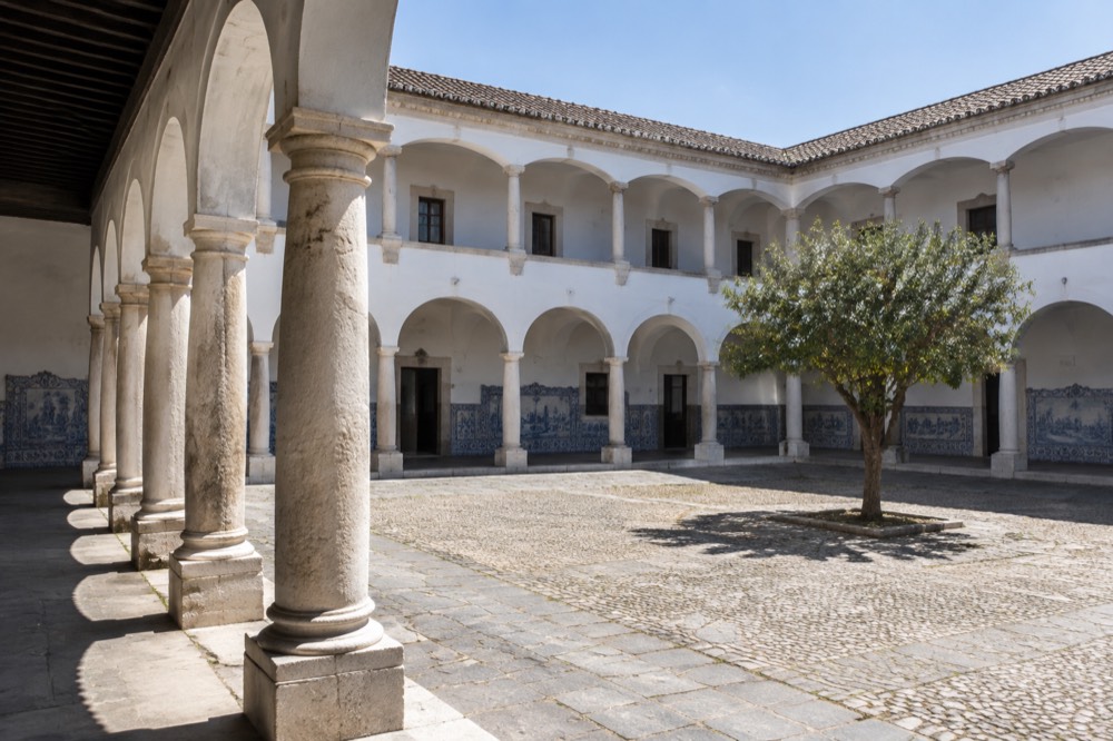 The azulejo-tiled cloister of the University of Évora under a blue sky
