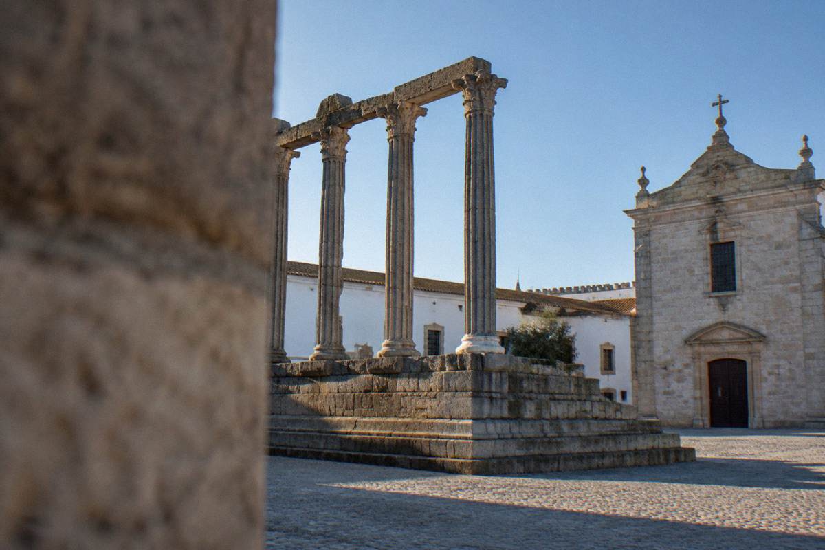 Slender granite columns on a stone platform lit softly from below against a dark blue sky