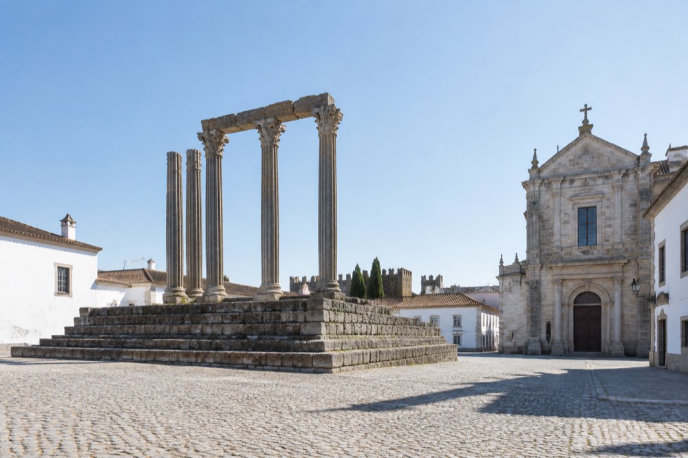 The Roman temple and white-walled streets of Évora's historic centre under a clear sky