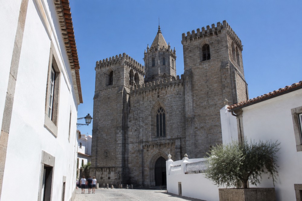 The Gothic towers of Évora Cathedral seen from a narrow cobbled street in the historic centre