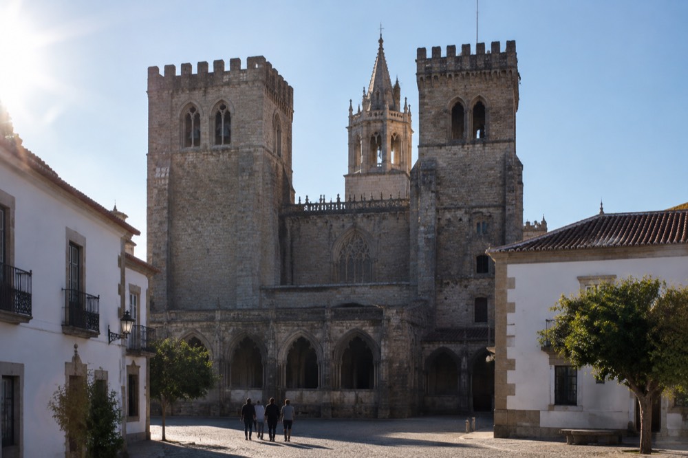 The Gothic arches of the Évora cathedral cloister with sunlight on the stone
