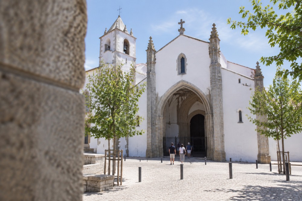 The exterior of the Igreja de São Francisco in Évora with visitors at the entrance