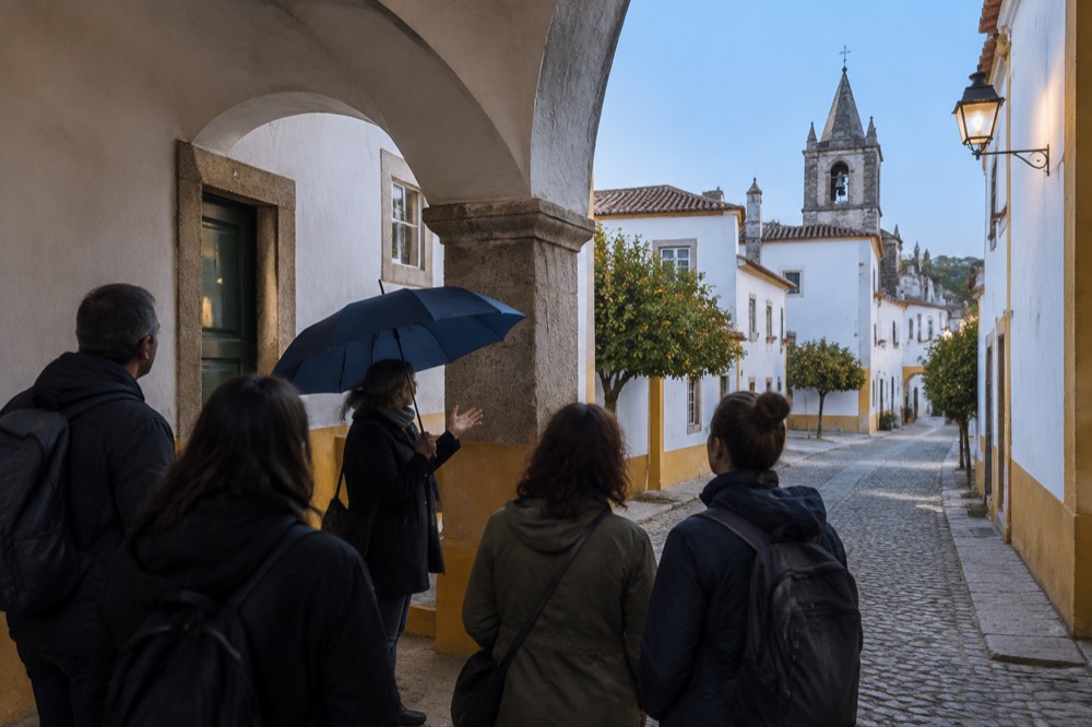 Guide with umbrella speaking to a small group under an archway in Évora's old town