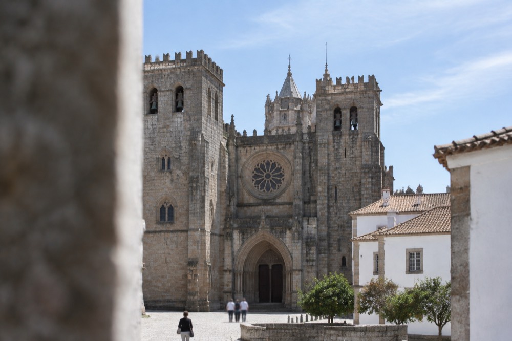 The Gothic interior of Évora cathedral with its stone columns and rose window light